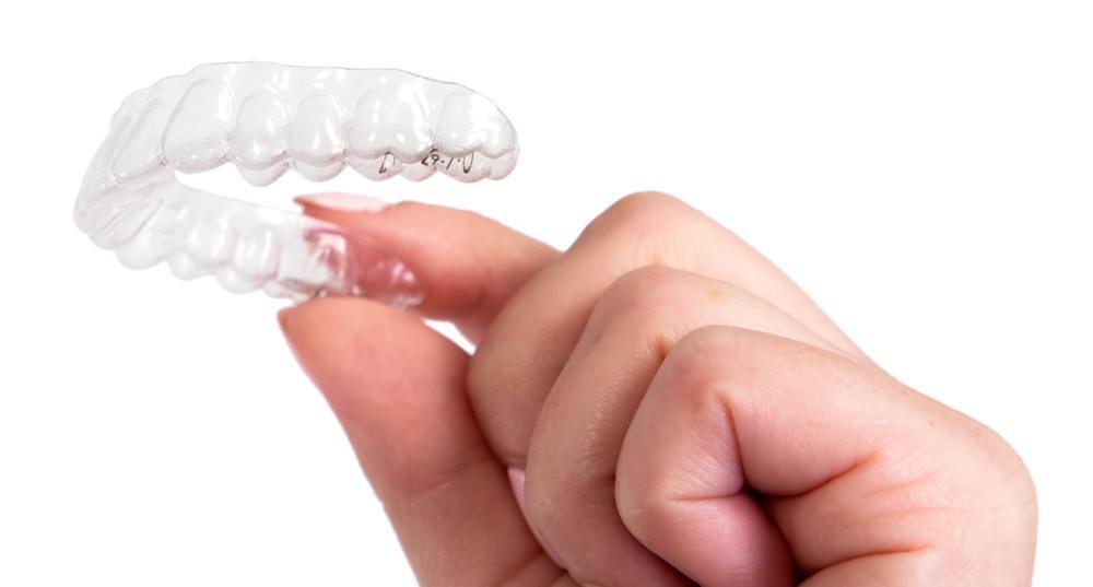 Hand holding up ClearCorrect clear aligners in Rockville, MD