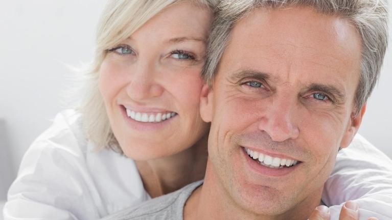 Couple with dental implants smiling in Rockville, MD