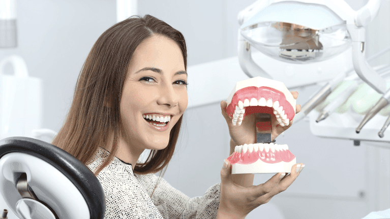 Dentist near me showing model of dental implant in Rockville