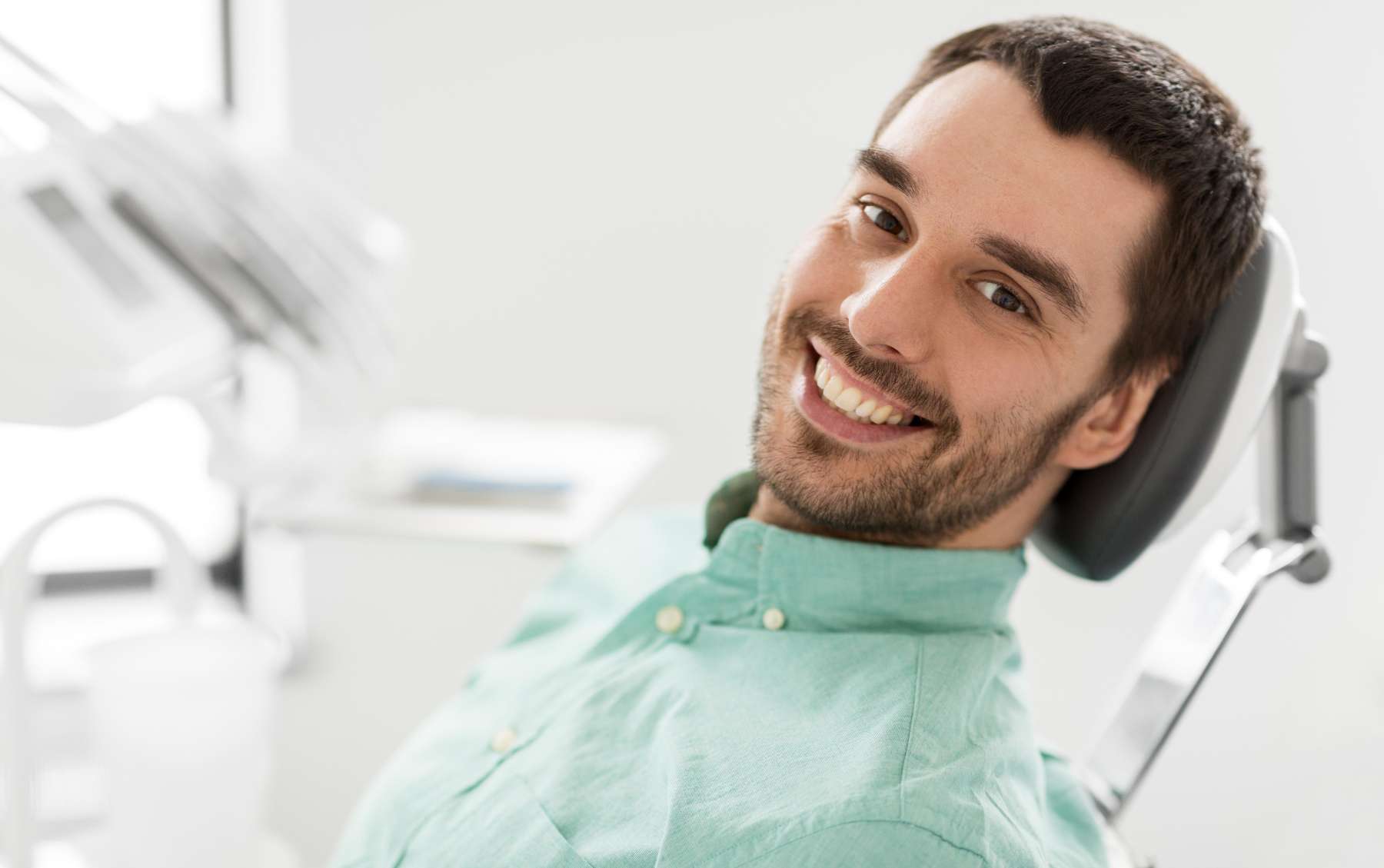 Patient in treatment room smiling after dental exam in Rockville, MD
